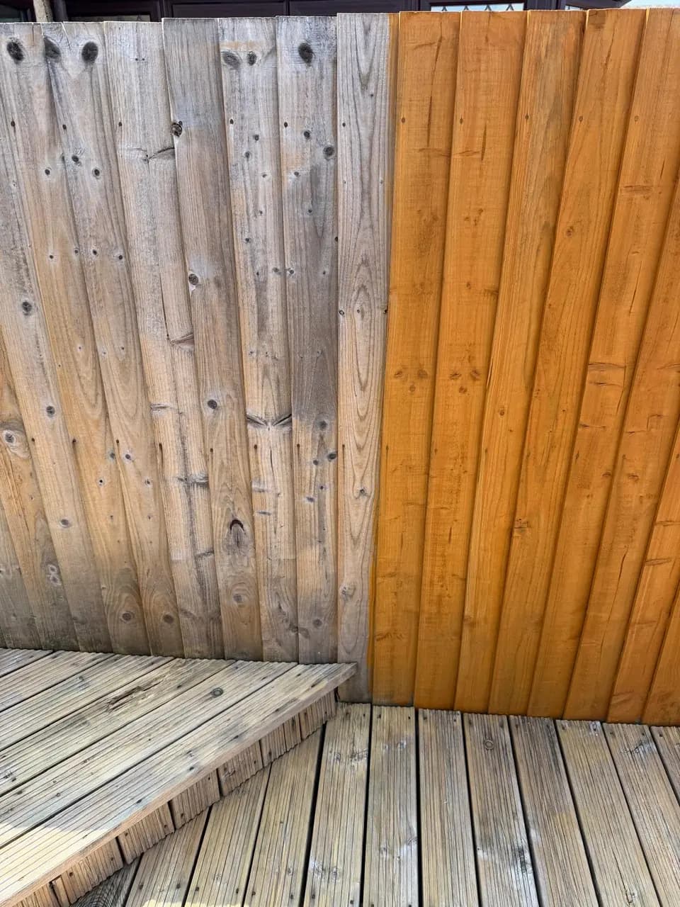 Close-up comparison between grey weathered fence boards and freshly treated boards