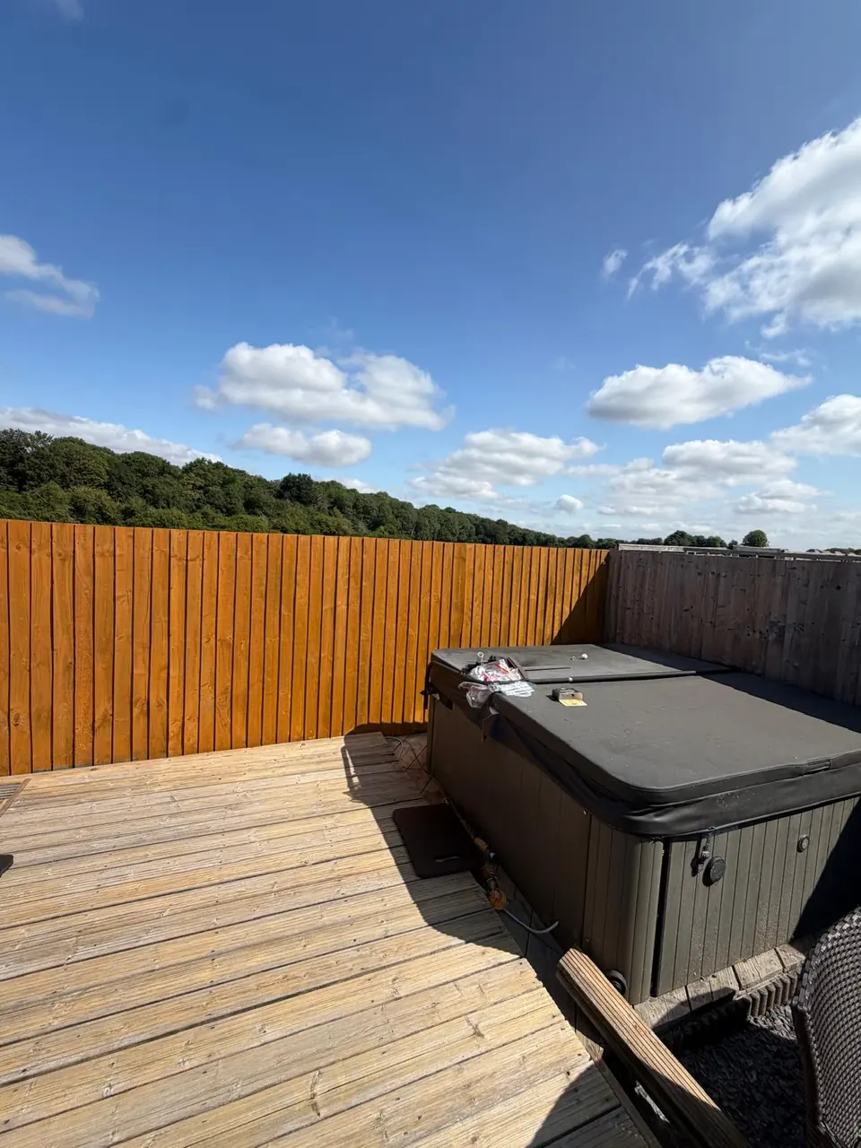 Freshly treated fencing beside a fixed garden hot tub while restoration work continues