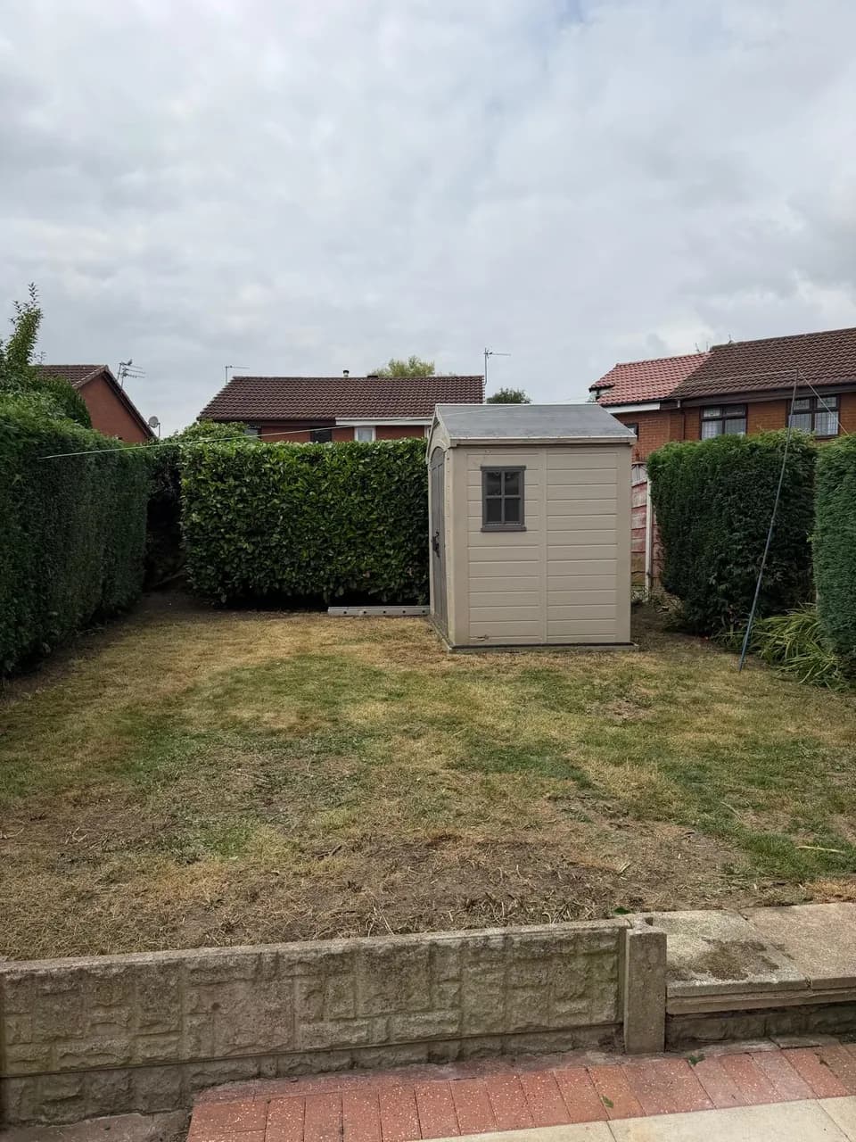 Freshly cut lawn and shaped hedges surrounding a garden shed in Warrington