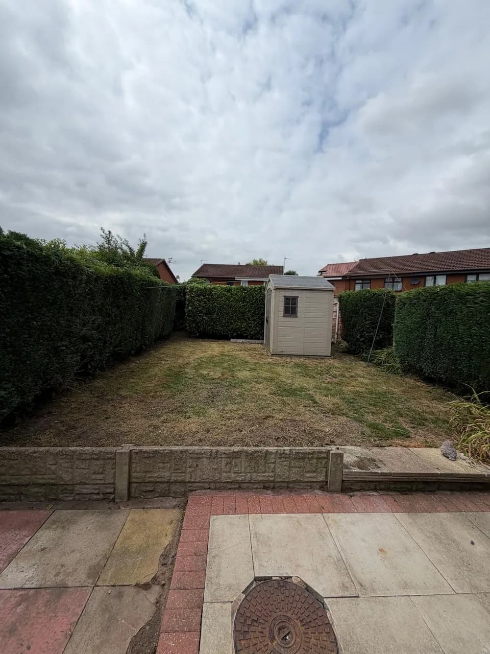 Wide view of the mown lawn and neatly shaped hedges after garden maintenance