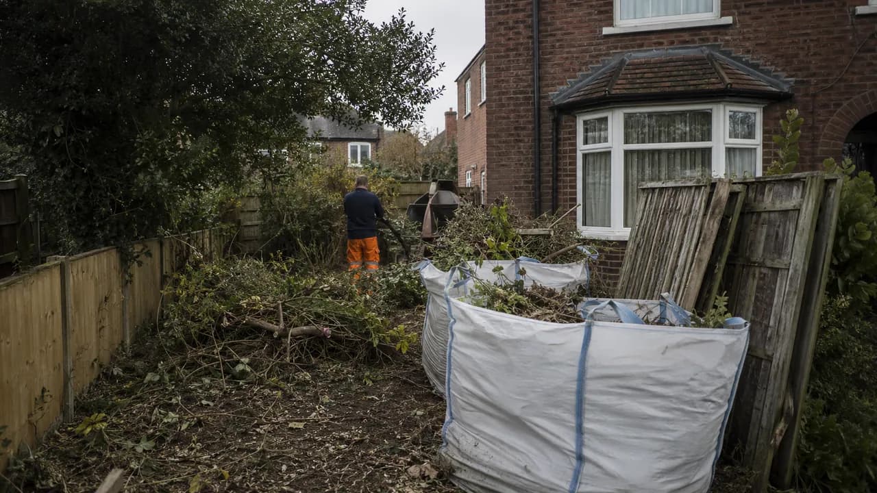 Garden clearance in progress on a 1930s brick semi with a bay window on a Stockton Heath street, Warrington, Cheshire