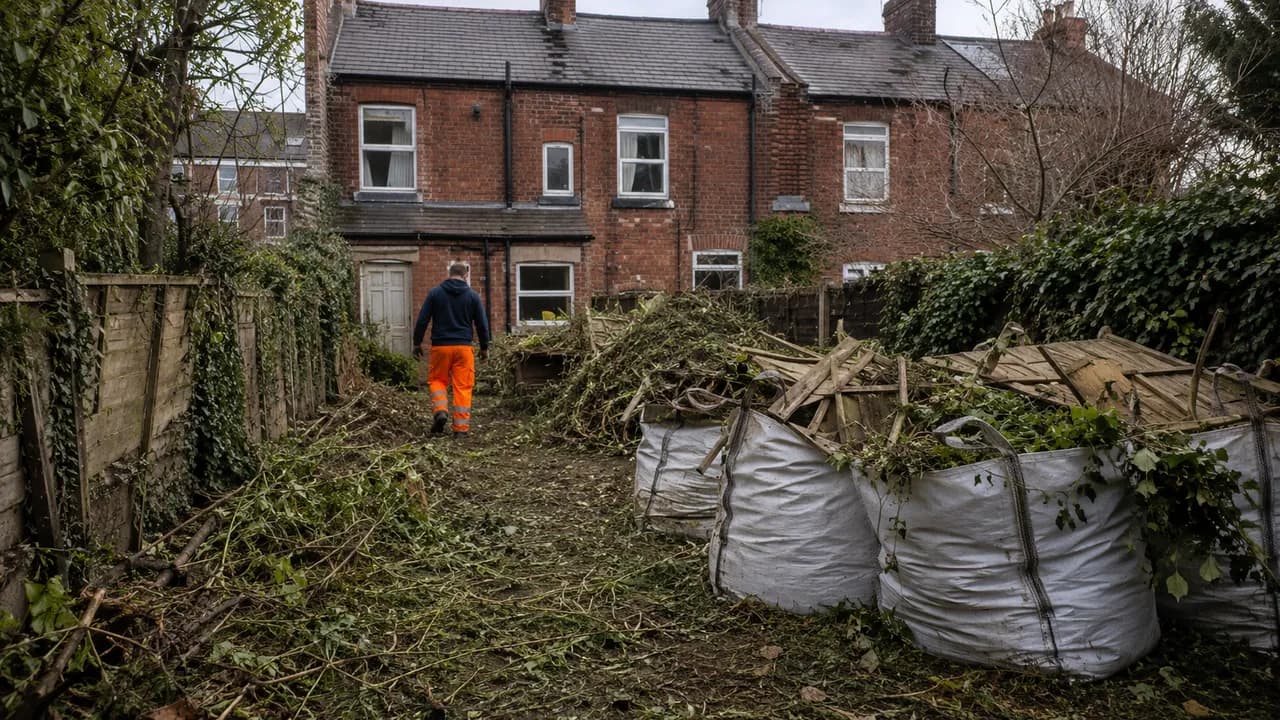 Garden clearance in progress on a Victorian brick terrace with a slate roof on a Widnes street, Cheshire, overcast