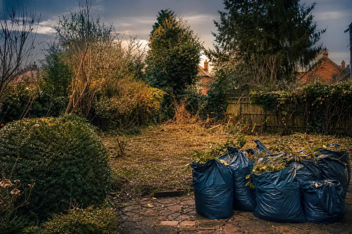Overgrown Chester back garden being cleared of green waste and rubbish, with bags loaded for licensed removal