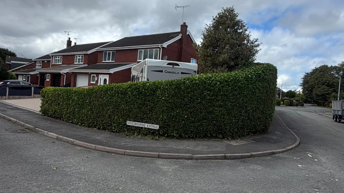 Finished 35-metre laurel hedge reduced and trimmed by CPAGM, with the pavement cleared