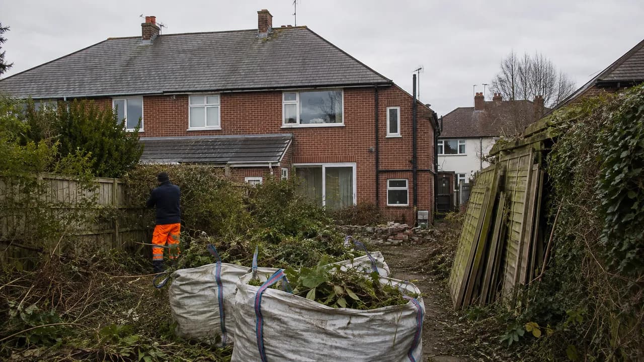 Garden clearance in progress on a 1960s brick semi in a coastal Deeside estate with a grey slate roof and open, exposed sky